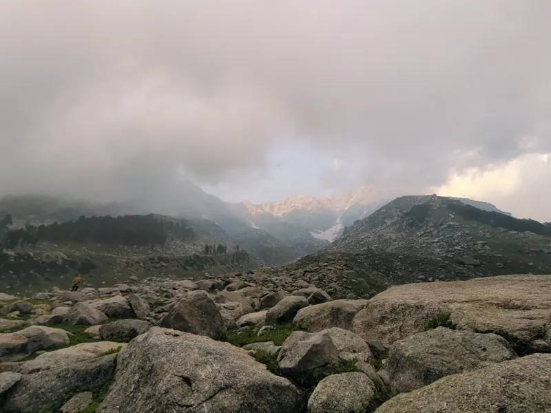 Grey storm clouds rolling over a forested mountain valley
